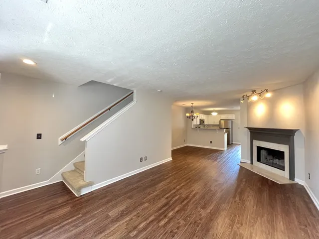 a view of a livingroom with wooden floor and a fireplace