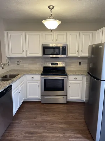 a kitchen with stainless steel appliances a stove a sink and a refrigerator