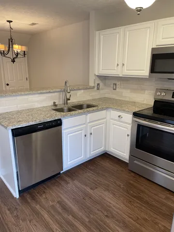 a kitchen with sink a microwave and cabinets