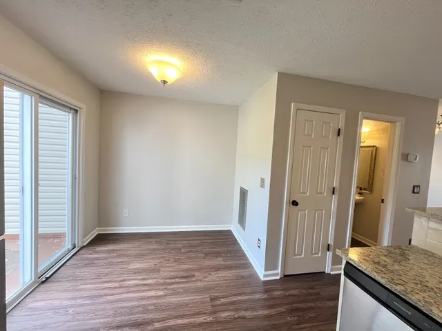 a view of a hallway with wooden floor and closet area