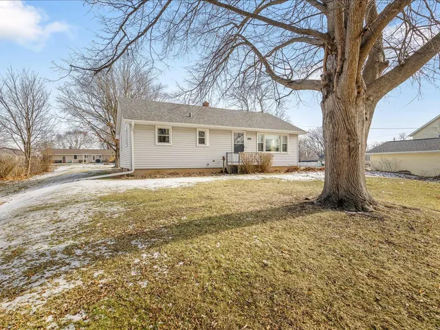 a view of a yard with a house and a large tree