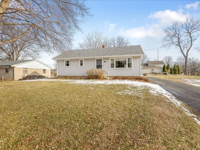 a front view of house with yard and trees around