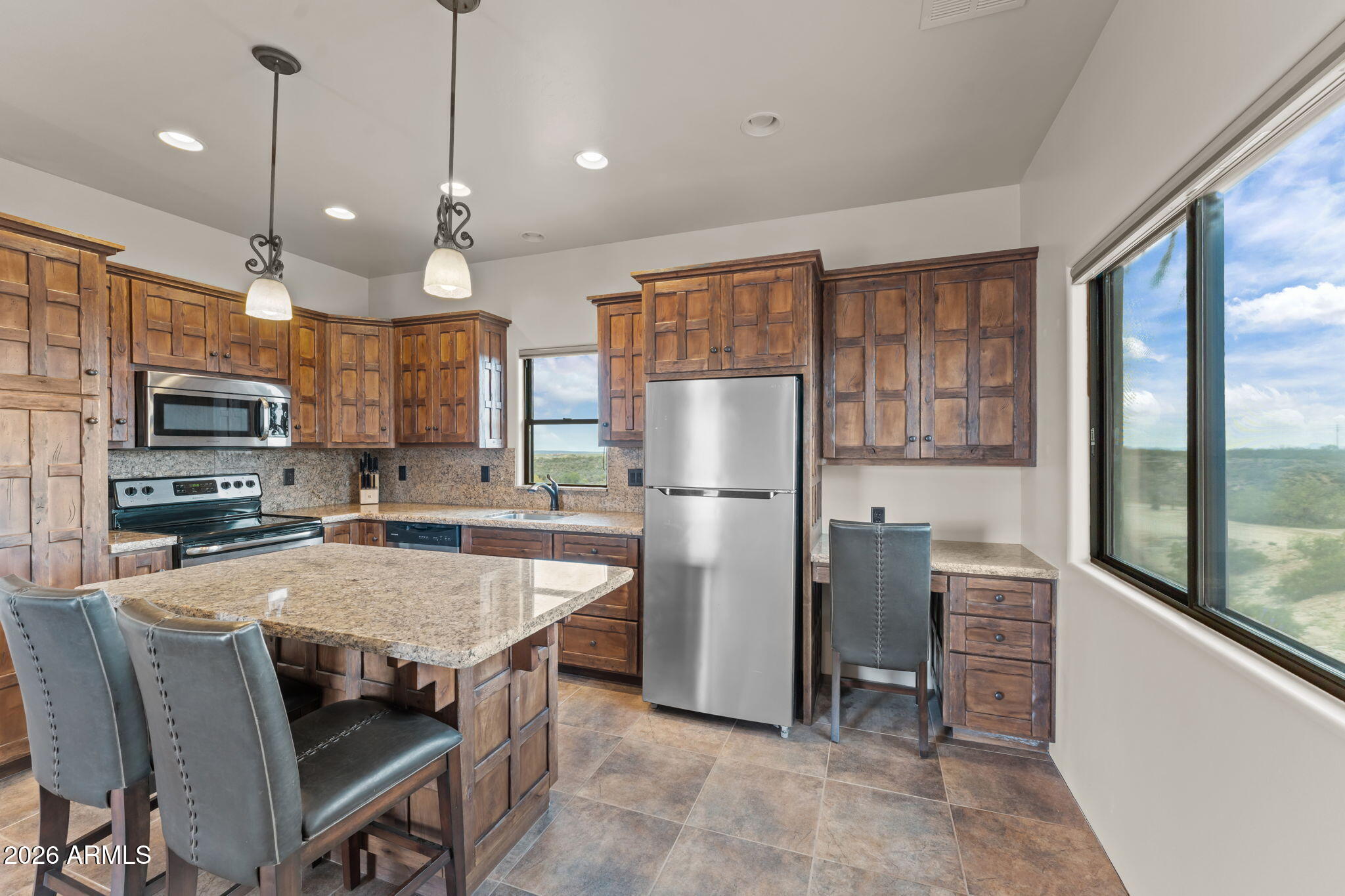 21800 West Hawkeye Road Congress, AZ 85332 - Photo 57 of 61 a kitchen with stainless steel appliances granite countertop a refrigerator a stove a sink a dining table and chairs