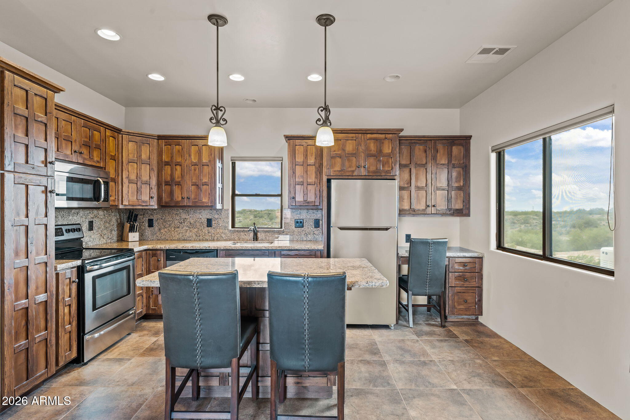 21800 West Hawkeye Road Congress, AZ 85332 - Photo 58 of 61 a kitchen with stainless steel appliances granite countertop a stove top oven a refrigerator a dining table and chairs with wooden floor