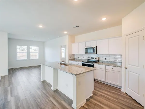 a kitchen with granite countertop white cabinets and white appliances