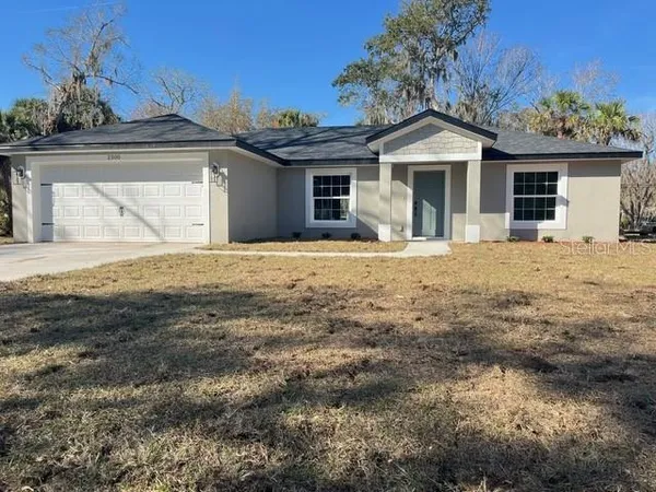a front view of a house with a dirt yard and a fire pit