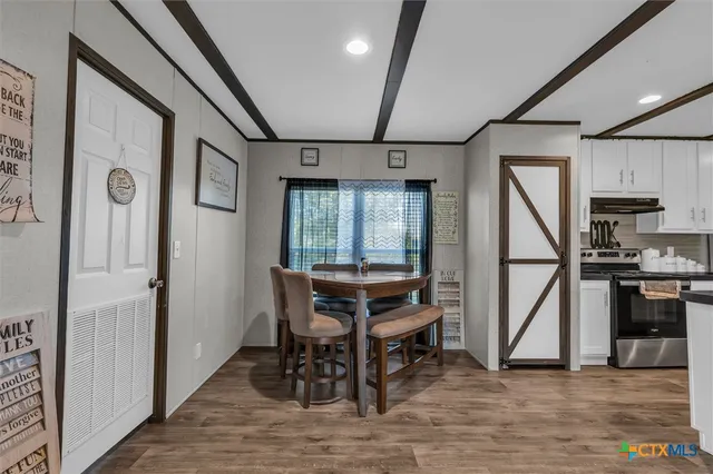 a dining room with wooden floor a chandelier and windows