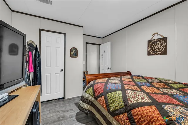 a bedroom with a bed and a flat screen tv