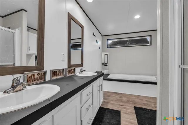 a bathroom with a granite countertop sink a mirror and a shower