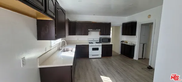 a kitchen with stainless steel appliances a stove top oven a sink and a refrigerator