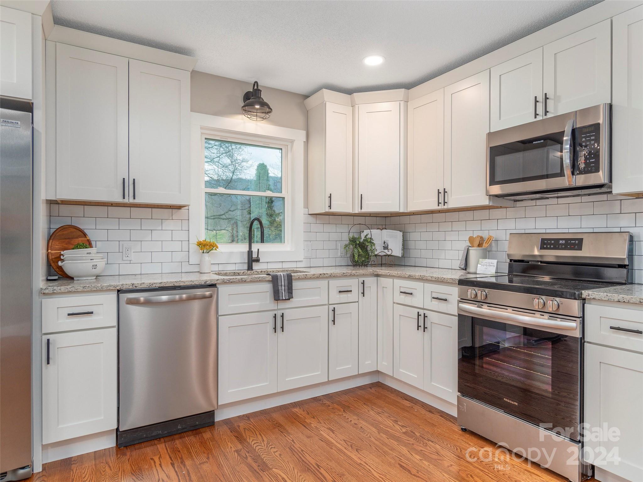 65 Squaw Ridge Road Waynesville, NC 28786 - Photo 14 of 24 a kitchen with white cabinets stainless steel appliances and sink