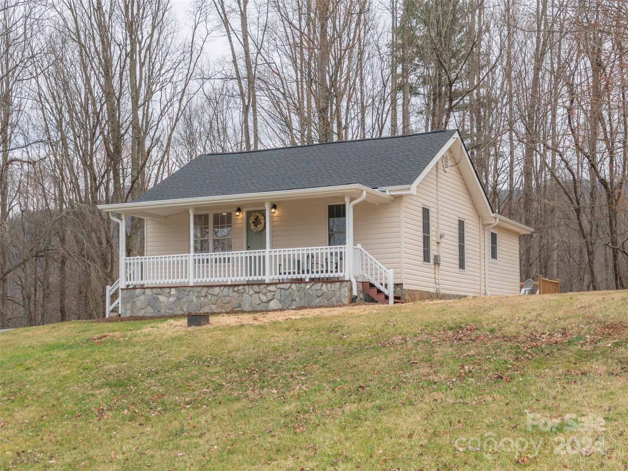 65 Squaw Ridge Road Waynesville, NC 28786 - Photo 3 of 24 a house that has a big yard with large trees