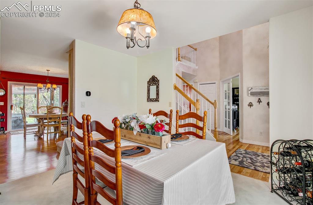 12110 Lazy E Road Peyton, CO 80831 - Photo 11 of 50 a view of a dining room with furniture wooden floor and chandelier