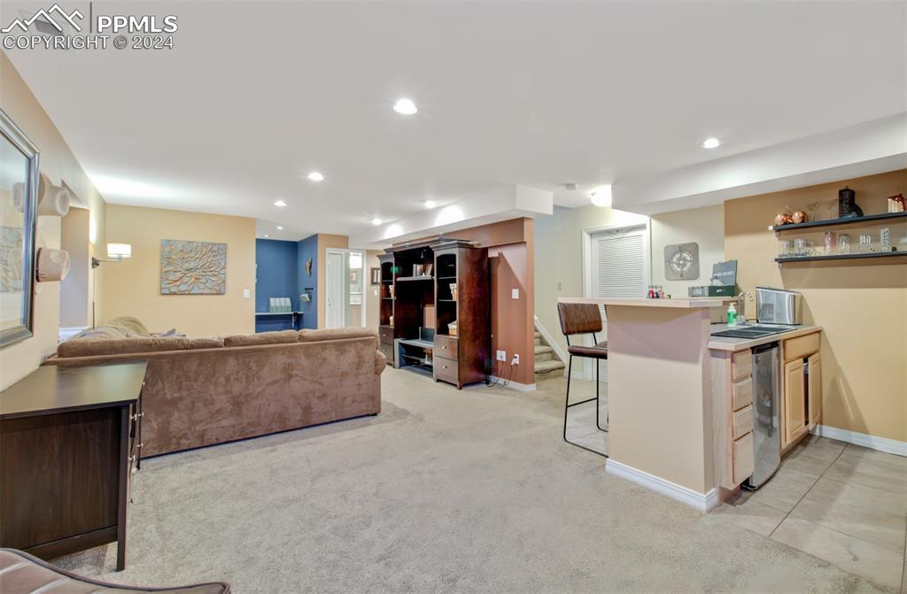12110 Lazy E Road Peyton, CO 80831 - Photo 23 of 50 a large white kitchen with stainless steel appliances kitchen island a large counter top and a living room view
