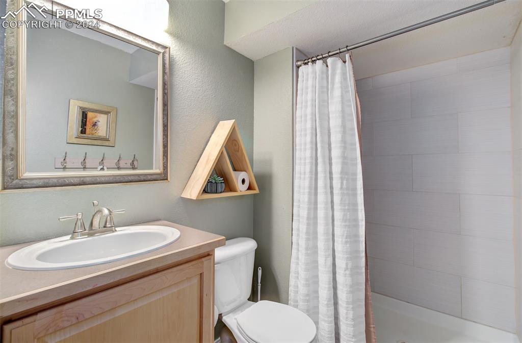 12110 Lazy E Road Peyton, CO 80831 - Photo 29 of 50 a bathroom with a sink toilet and a mirror