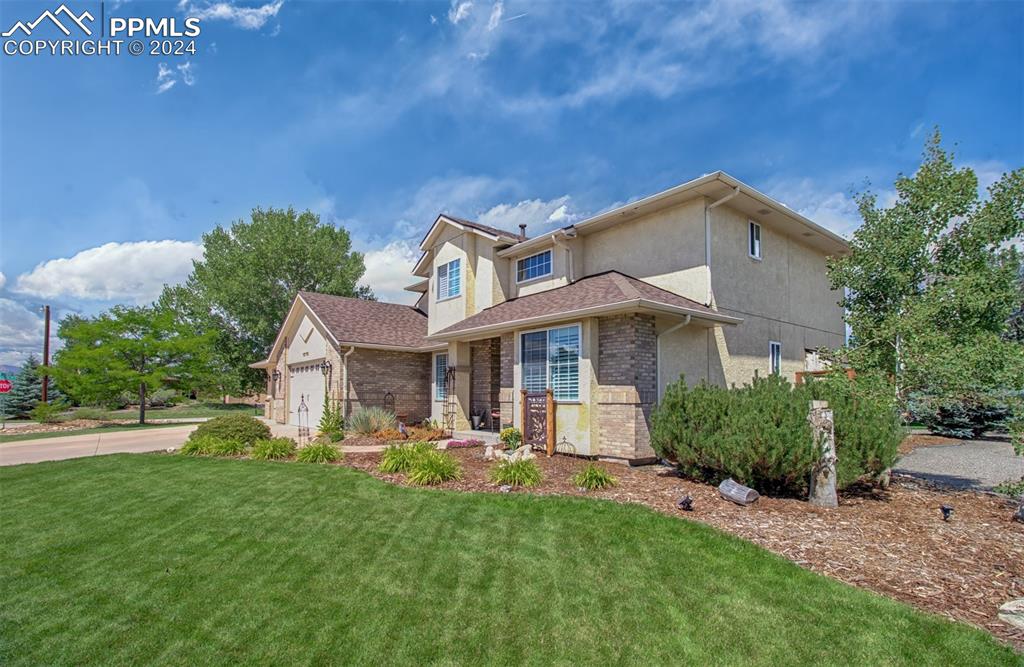 12110 Lazy E Road Peyton, CO 80831 - Photo 32 of 50 a front view of a house with a garden and plants