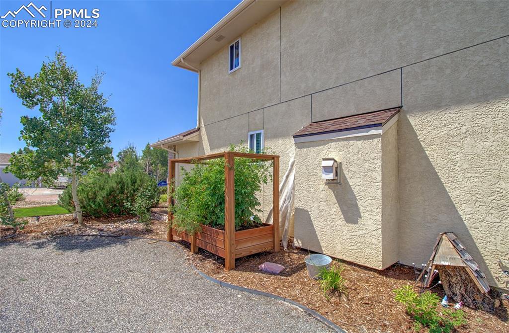 12110 Lazy E Road Peyton, CO 80831 - Photo 37 of 50 a backyard of a house with a garden and deck
