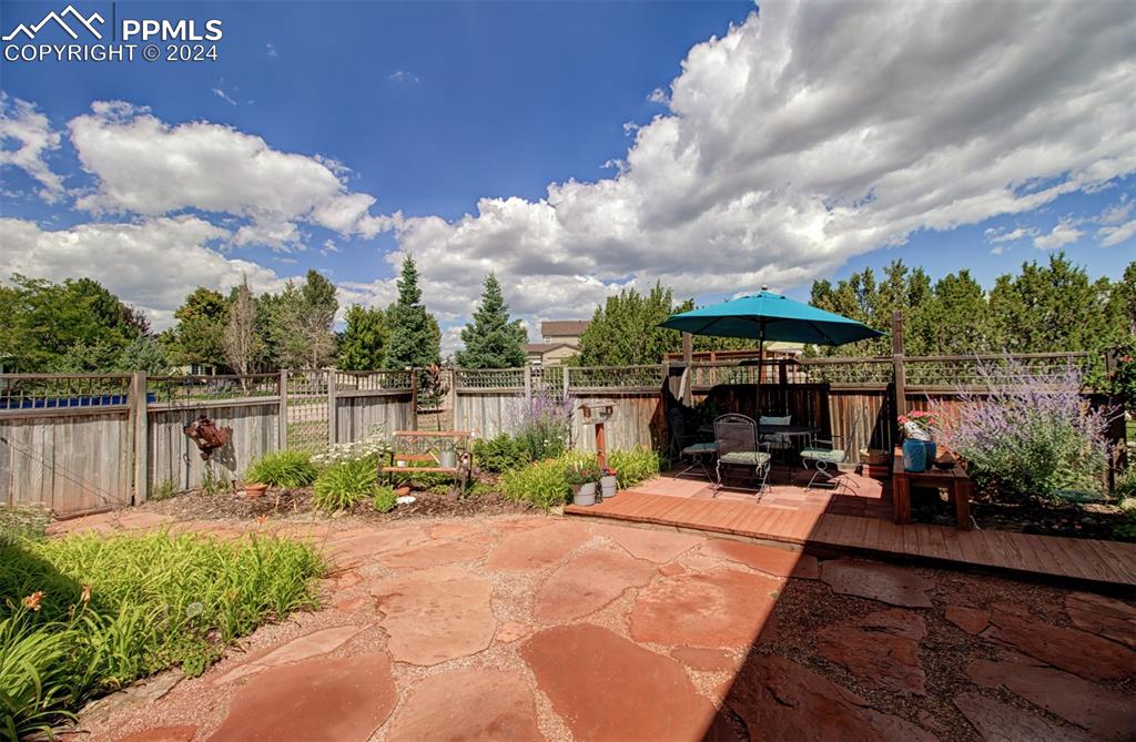 12110 Lazy E Road Peyton, CO 80831 - Photo 45 of 50 a view of a chair and tables under an umbrella