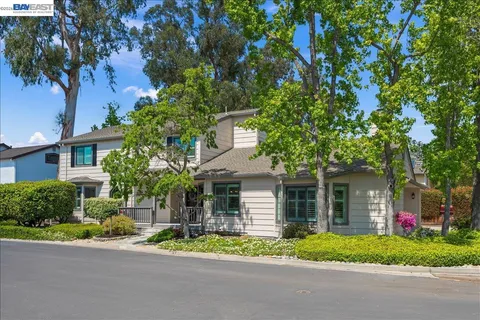 a front view of a house with a yard and tree s