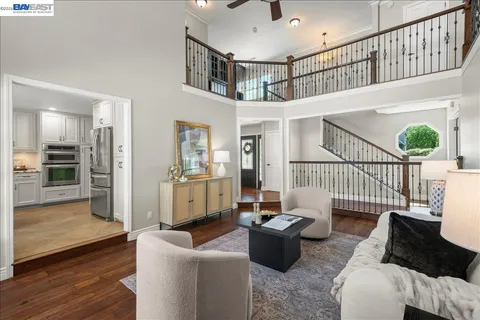 a kitchen with stainless steel appliances granite countertop wooden cabinets a stove top oven a sink and dishwasher a refrigerator with wooden floor