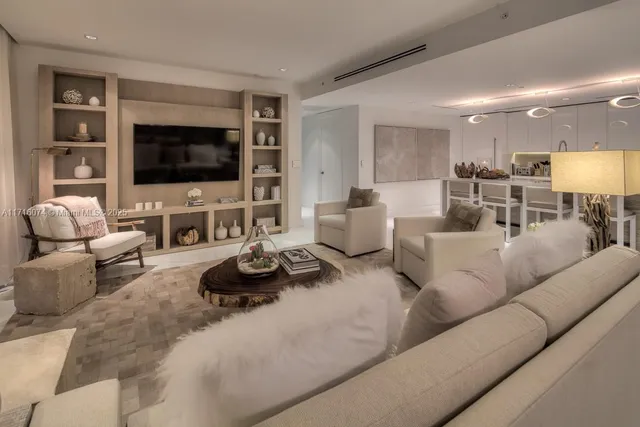 a living room with furniture kitchen view and a flat screen tv