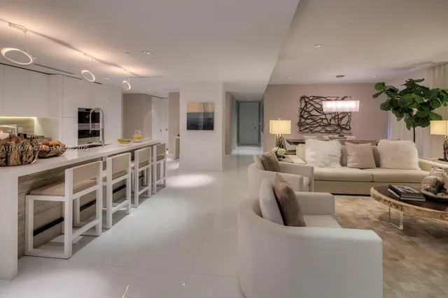 a living room with furniture kitchen view and a large window