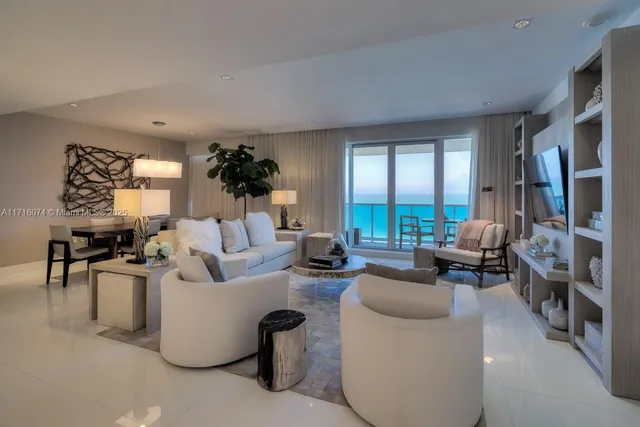 a living room with fireplace furniture and a large window