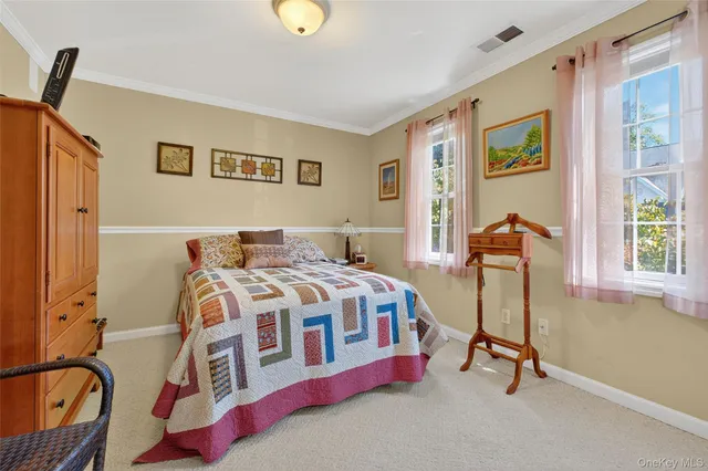 a bedroom with a bed a dresser and a window