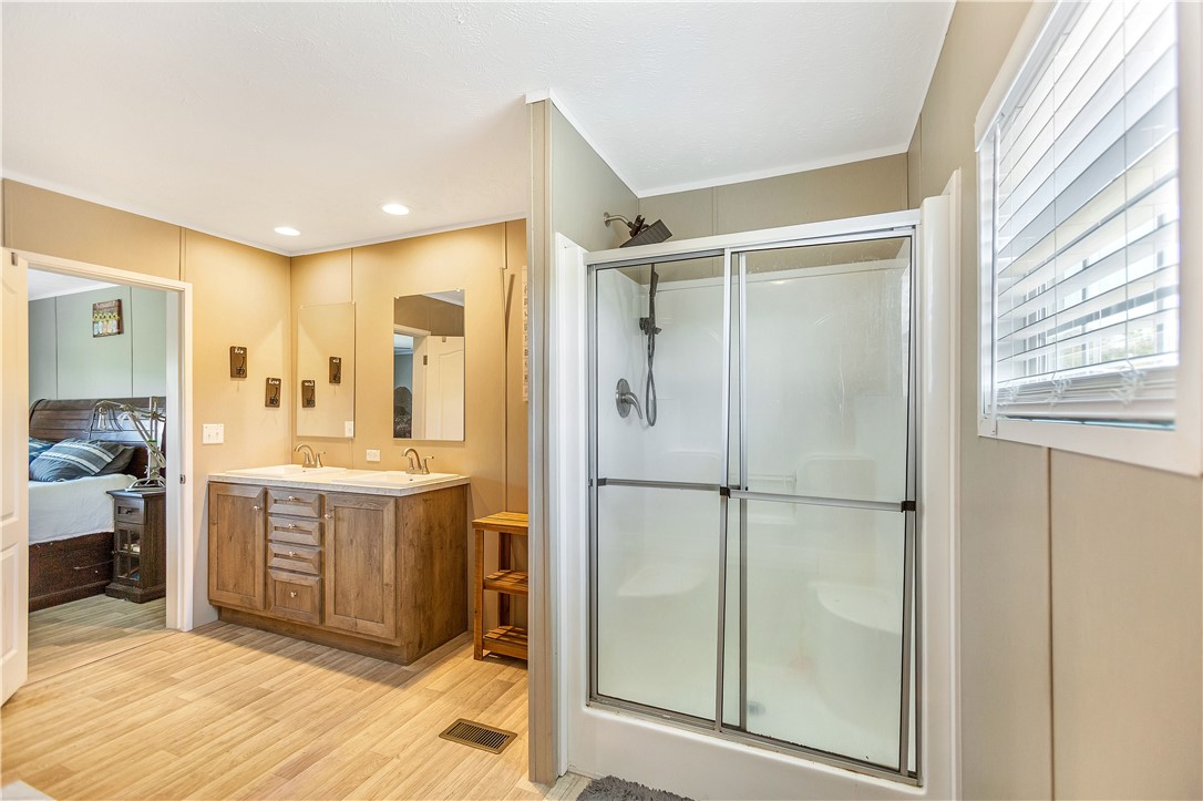 633 Project Road Iva, SC 29655 - Photo 19 of 38 This primary bathroom offers a double vanity and a glass-enclosed shower.
