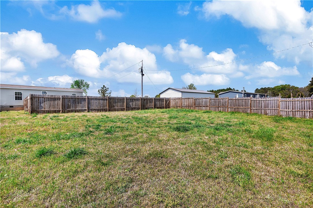 633 Project Road Iva, SC 29655 - Photo 33 of 38 A spacious backyard enclosed by a sturdy wooden fence offers ample room for outdoor activities.