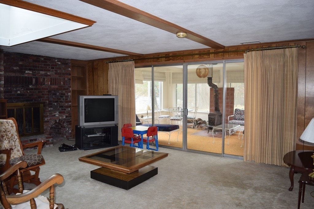 71 Old Stage Road Chelmsford, MA 01824 - Photo 6 of 15 a living room with furniture a flat screen tv and a fireplace