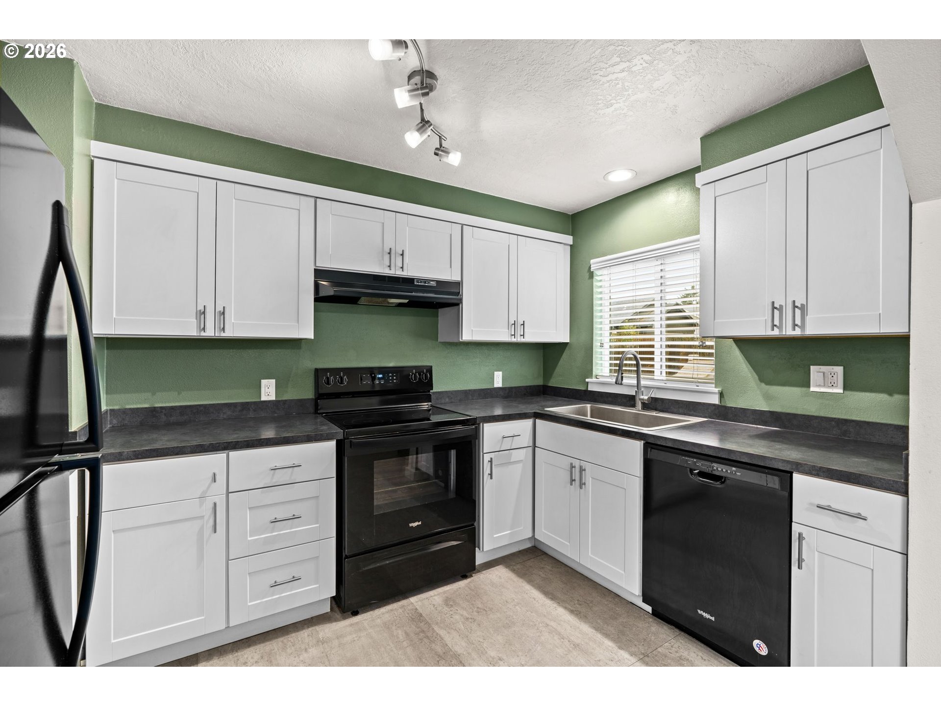 3155 Bell Avenue Eugene, OR 97402 - Photo 10 of 30 a kitchen with granite countertop white cabinets sink and stainless steel appliances