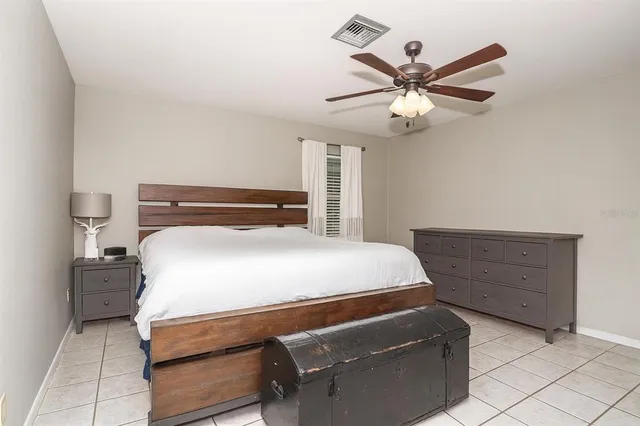 a bedroom with a bed and a ceiling fan