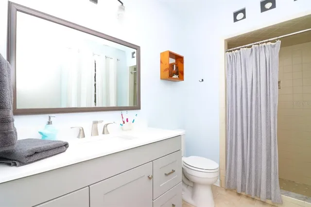 a bathroom with a sink a toilet and mirror