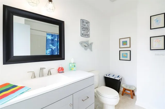 a bathroom with a sink vanity mirror and toilet