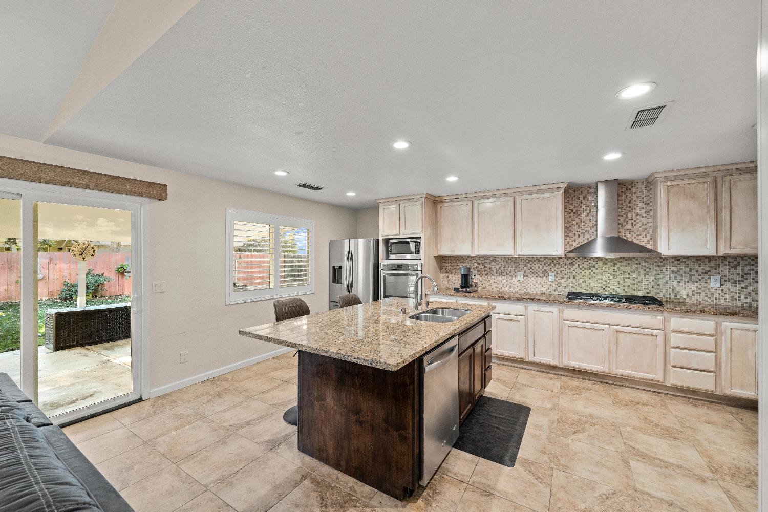 2768 Butte House Road Yuba City, CA 95993 - Photo 11 of 43 a large kitchen with kitchen island granite countertop a stove a sink a dining table and chairs