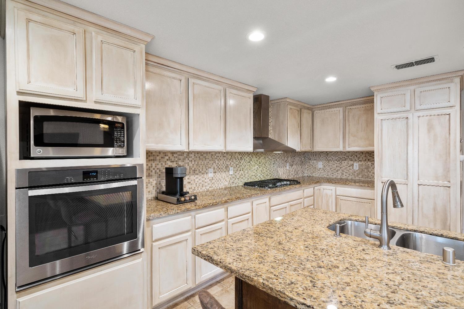2768 Butte House Road Yuba City, CA 95993 - Photo 15 of 43 a kitchen with granite countertop a stove microwave and refrigerator