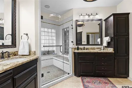 a bathroom with a granite countertop sink a mirror and a shower