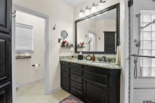 a bathroom with a granite countertop sink a mirror and a shower