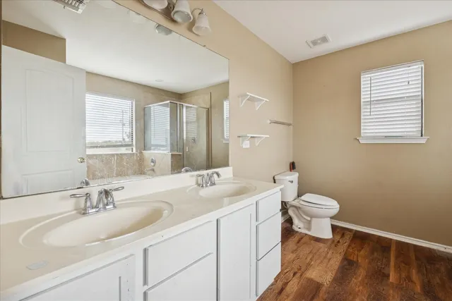 a bathroom with a sink a toilet and a mirror