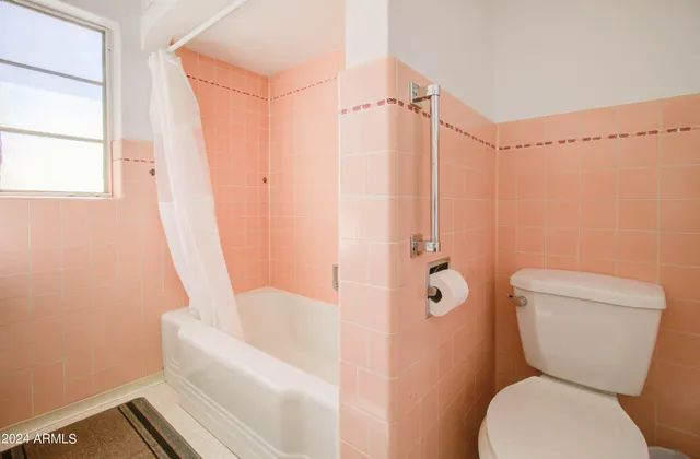 a living room with furniture and a refrigerator