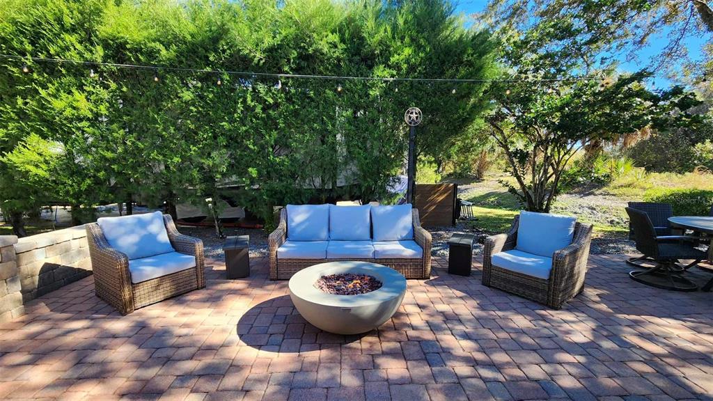 a view of a backyard with furniture and a fire pit