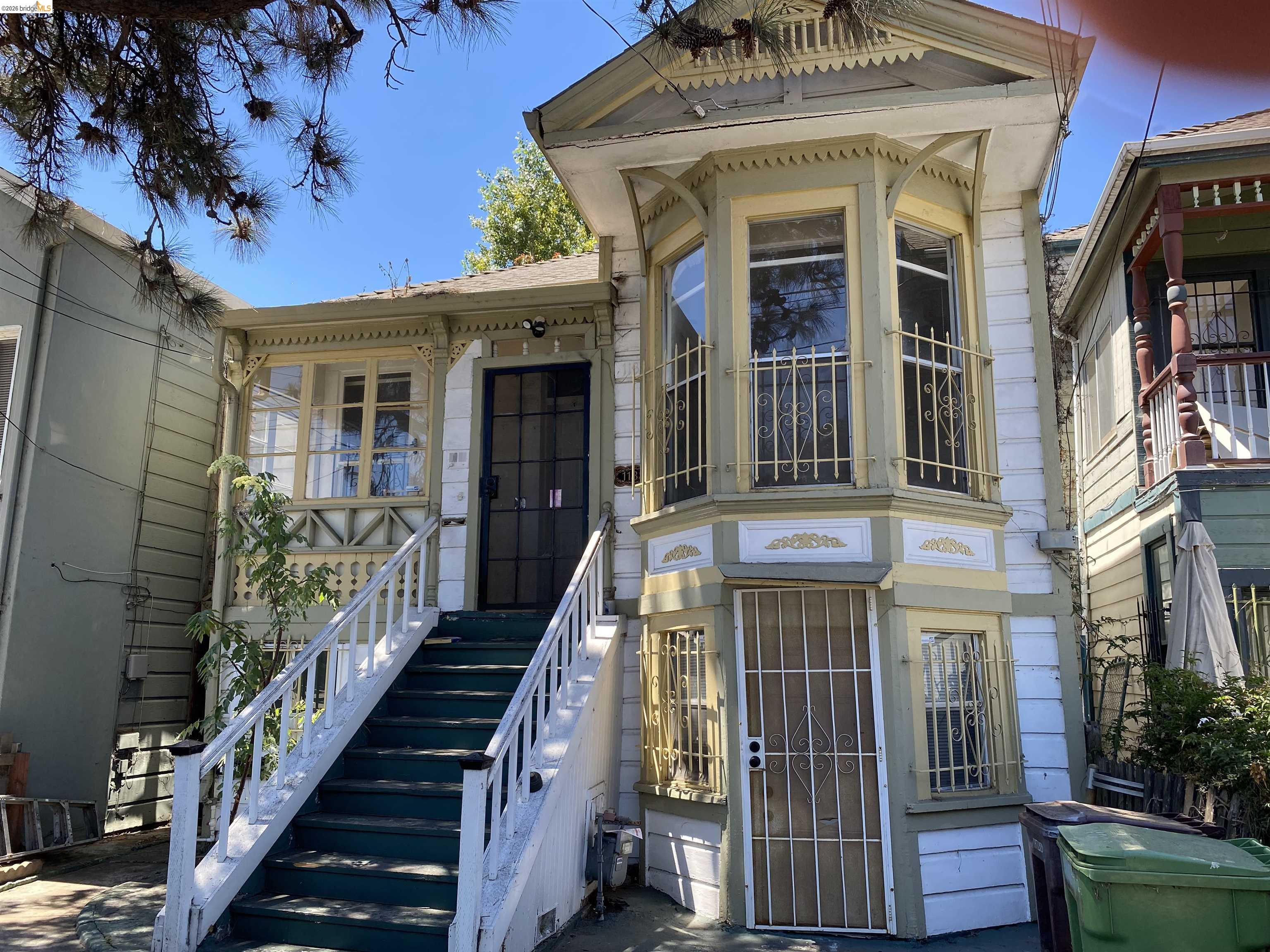 1133 Wood Street Oakland, CA 94607 - Photo 1 of 25 Victorian-style facade featuring an ornate bay window, detailed spindle work, a covered porch, and a dedicated exterior staircase