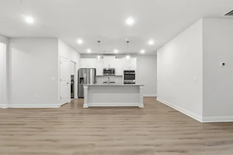 a view of kitchen with kitchen island microwave and cabinets