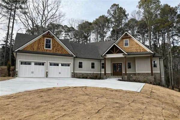 a front view of a house with a yard covered in snow