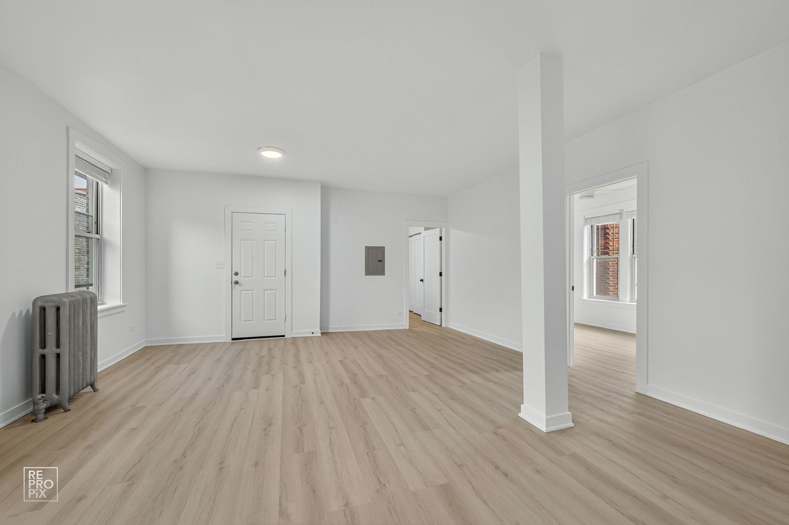 6975 North Bell Avenue, Unit 2 Chicago, IL 60645 - Photo 5 of 11 an empty room with wooden floor and windows