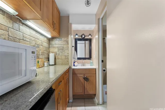 a bathroom with a granite countertop sink and mirror