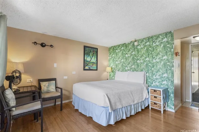 a bedroom with a bed and wooden floor