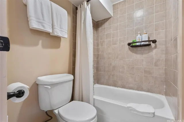a white toilet sitting next to a bath tub
