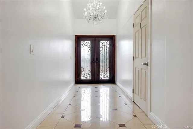 a view of a hallway with windows and chandelier